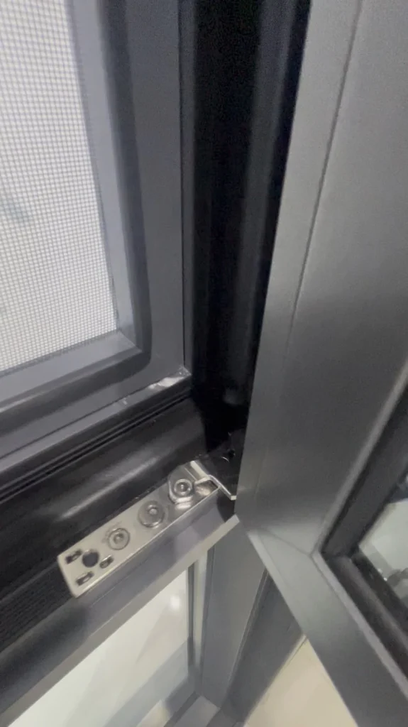 Lower hinge and frame corner of a 92 Series aluminum casement window
